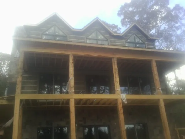 Dormers and porch framing on a large log home under construction — Roof Coating work by our crew in Gig Harbor